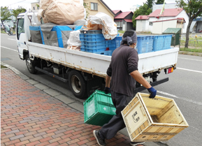 収集場所：トラックに積まれている専用カゴにステーションで収集したびんを積み込む イメージ画像